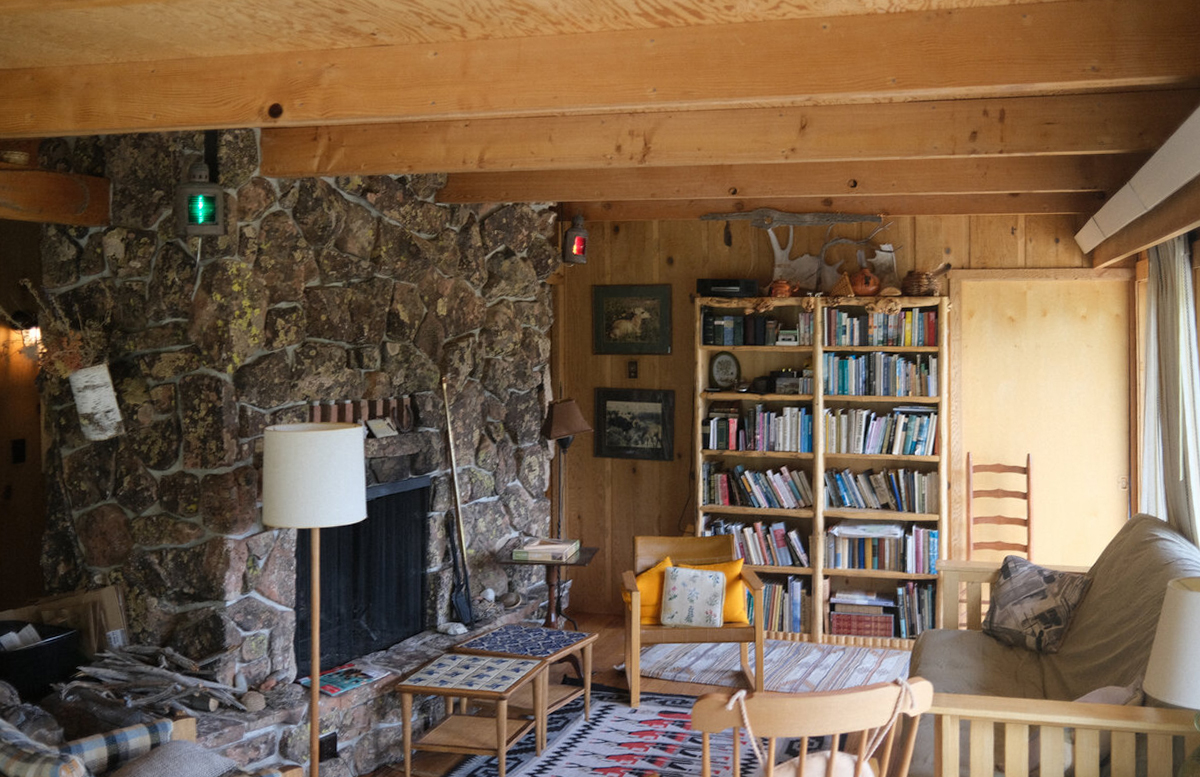 Living room with stone fireplace and bookshelves
